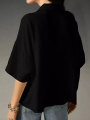 Black half sleeve shirt with a V-neck and relaxed fit, styled with jeans.