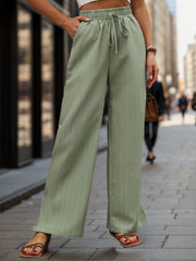 Sage linen blend palazzo trousers with drawstring waist and subtle vertical pinstripe detail.
