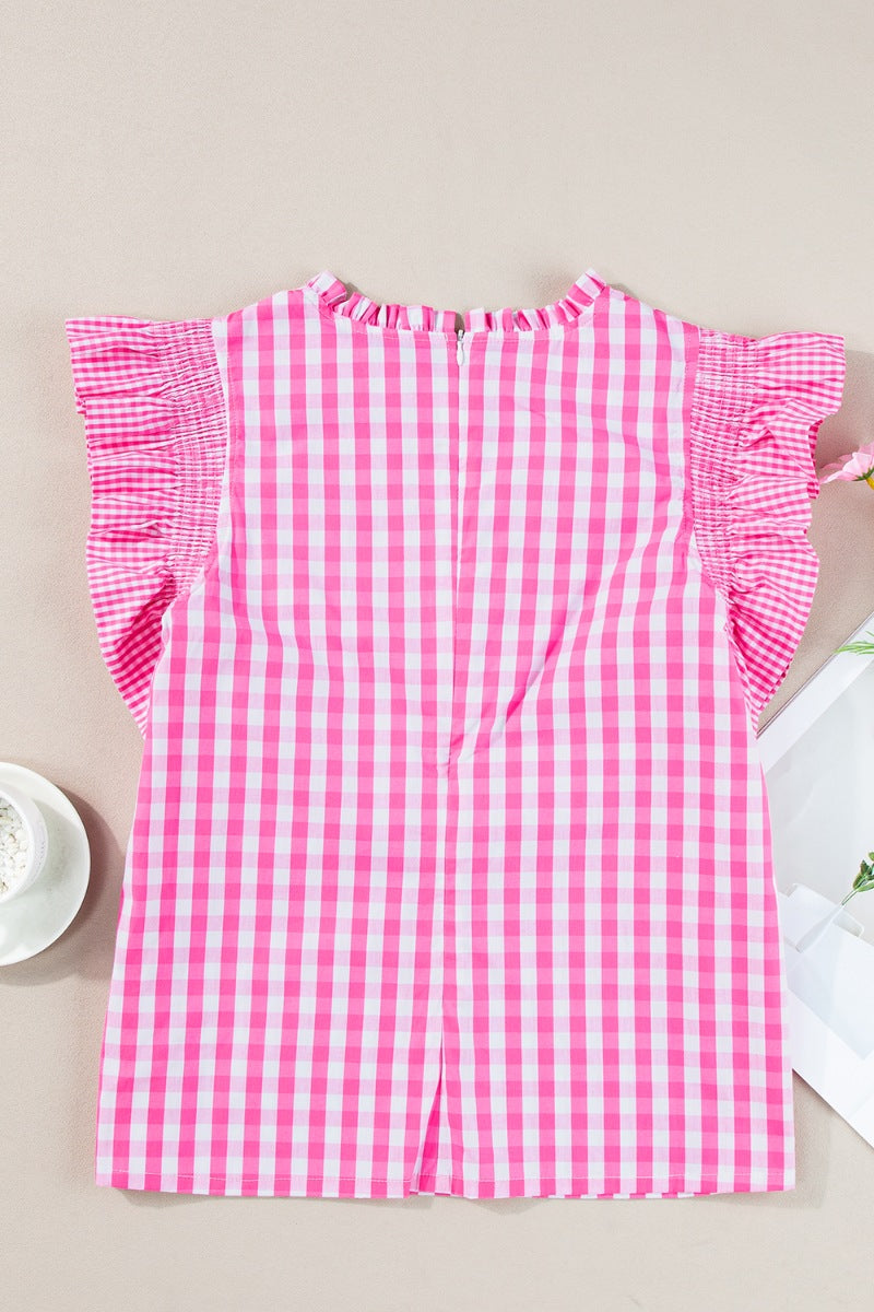 Fuchsia pink gingham blouse with ruffled cap sleeves and a ruffled neckline.