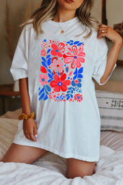 White oversized graphic tee dress with a vibrant floral print and short sleeves.
