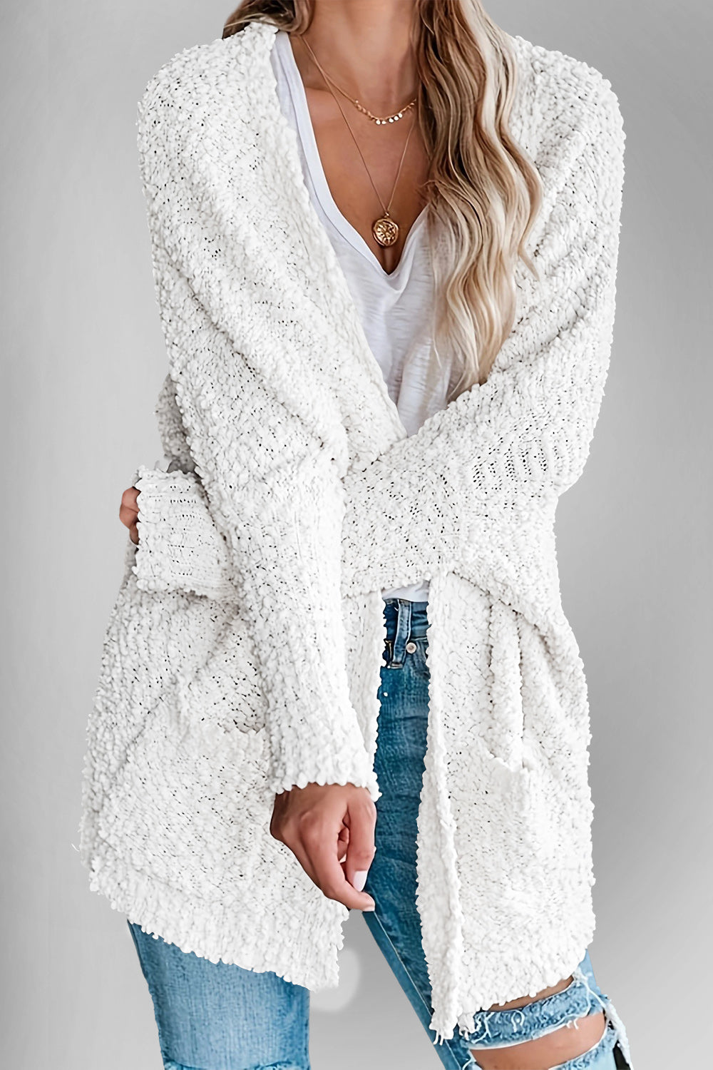 White popcorn knit open cardigan with pockets and a relaxed fit.