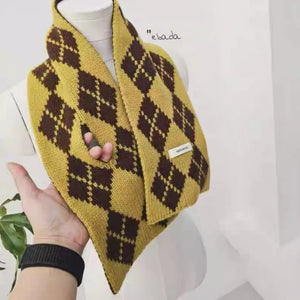 Cozy argyle pattern wool scarf in brown and yellow with a hand passing through a loop.
