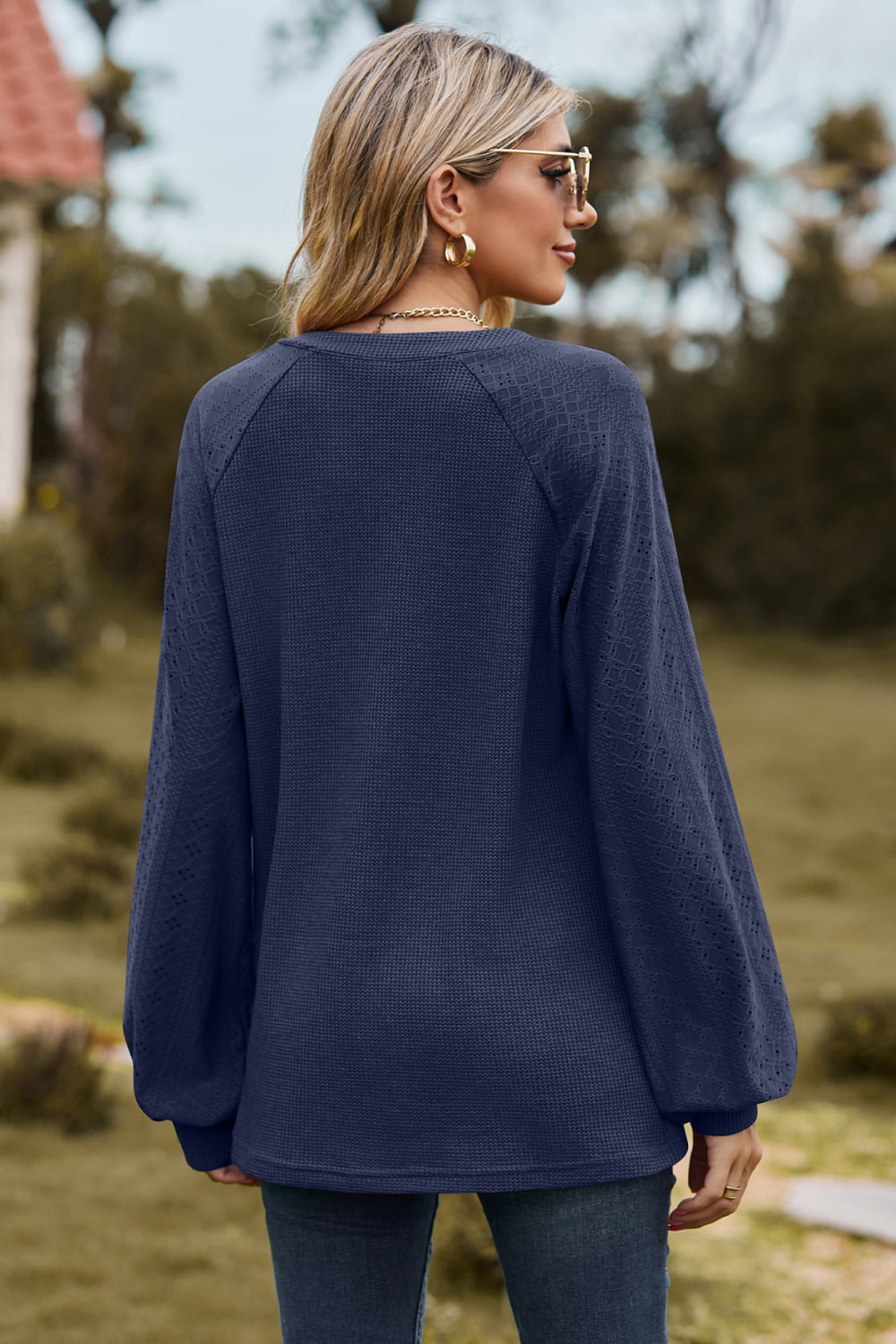 Dark blue waffle knit raglan sweater with laser cut detail on sleeves