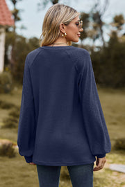 Dark blue waffle knit raglan sweater with laser cut detail on sleeves