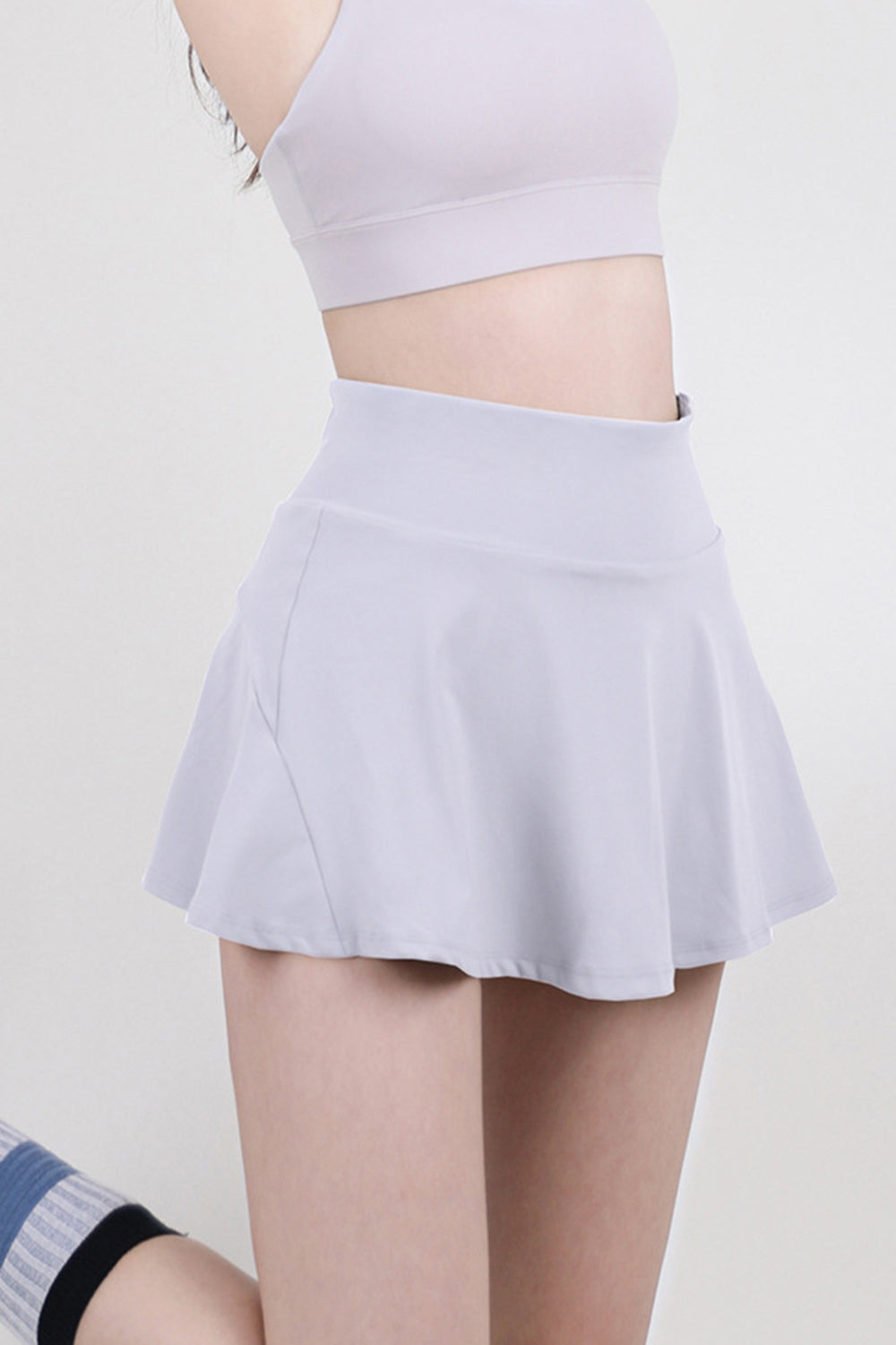 Sculpted flared skort in light purple with a high waist and breathable fabric.