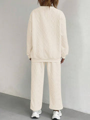 Beige cable knit lounge set with crewneck sweatshirt and wide-leg pants.