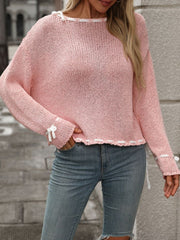 Dusty pink knit sweater with white stitched trim and bow details on sleeves and hem.