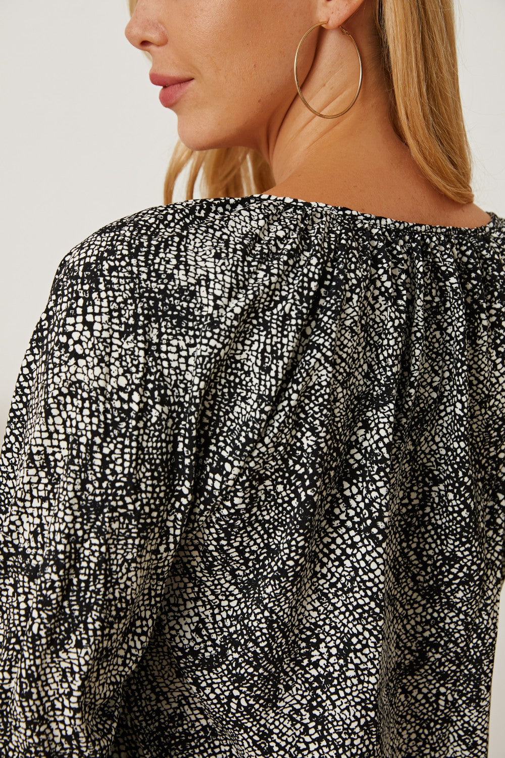 Black serpentine print blouse with gathered neckline and sleeves.