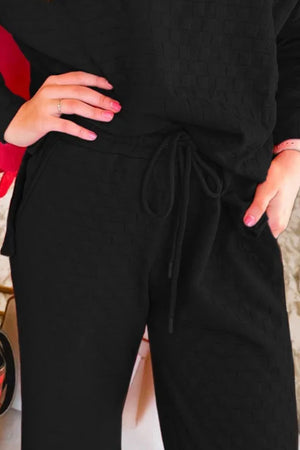 Black textured weave lounge set with drawstring waist and pockets.