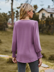 Dusty purple blouse with gathered yoke and smocked cuffs.