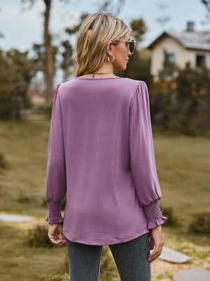 Dusty purple blouse with gathered yoke and smocked cuffs.