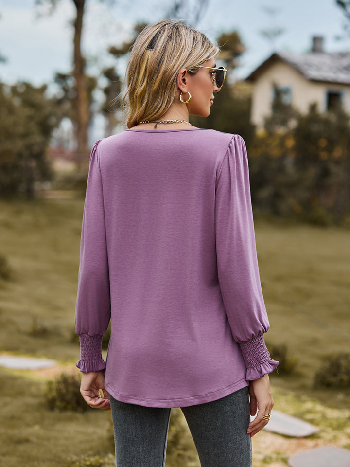 Dusty purple blouse with gathered yoke and smocked cuffs.