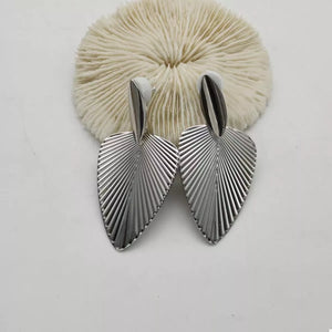 Silver leaf silhouette dangle earrings with textured surface detail.