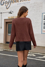 Brown acrylic knit cardigan with pearl buttons and patch pockets, long sleeves.