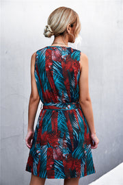 Floral mini dress with zip front and tie waist in teal and red palm print