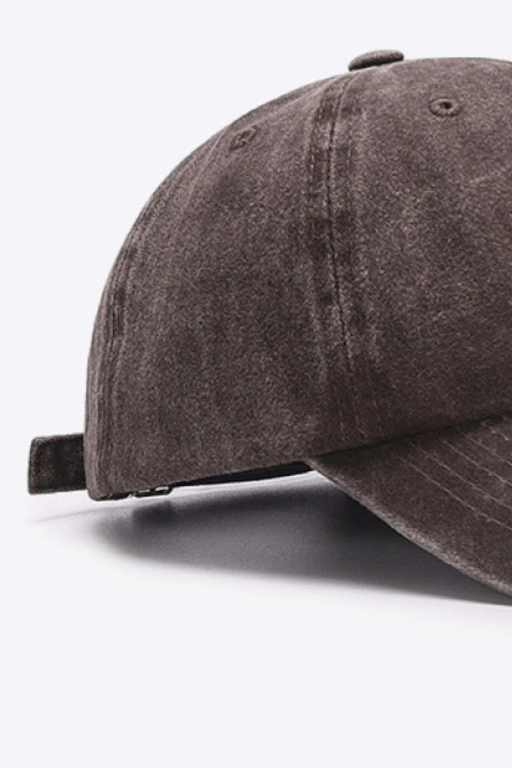 Washed cotton baseball cap in brown with adjustable strap detail.