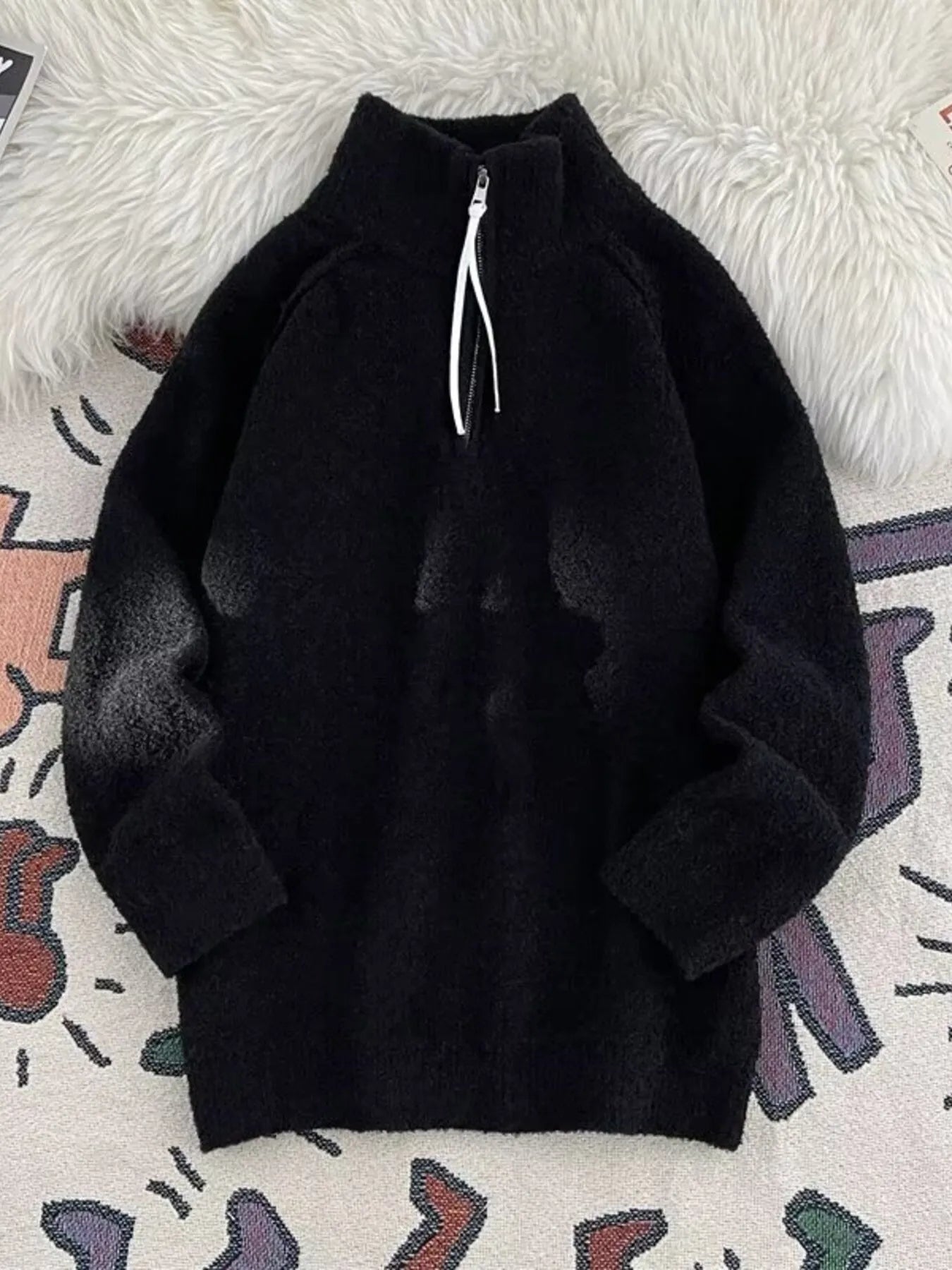 Men's black half-zip sweater with high neck and fuzzy texture.