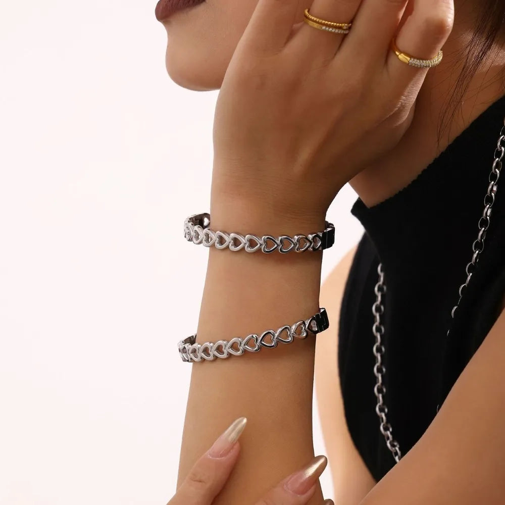 Silver heart motif chain bracelet with open heart links.