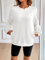 Relaxed fit white sweatshirt with crewneck, long sleeves, and front pockets.