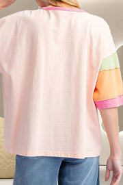 Blush pink raglan tee with colorblock sleeves in green, orange, and pink.