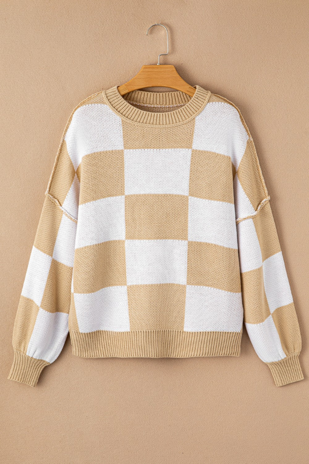 Checkerboard knit crewneck sweater in tan and white with balloon sleeves.