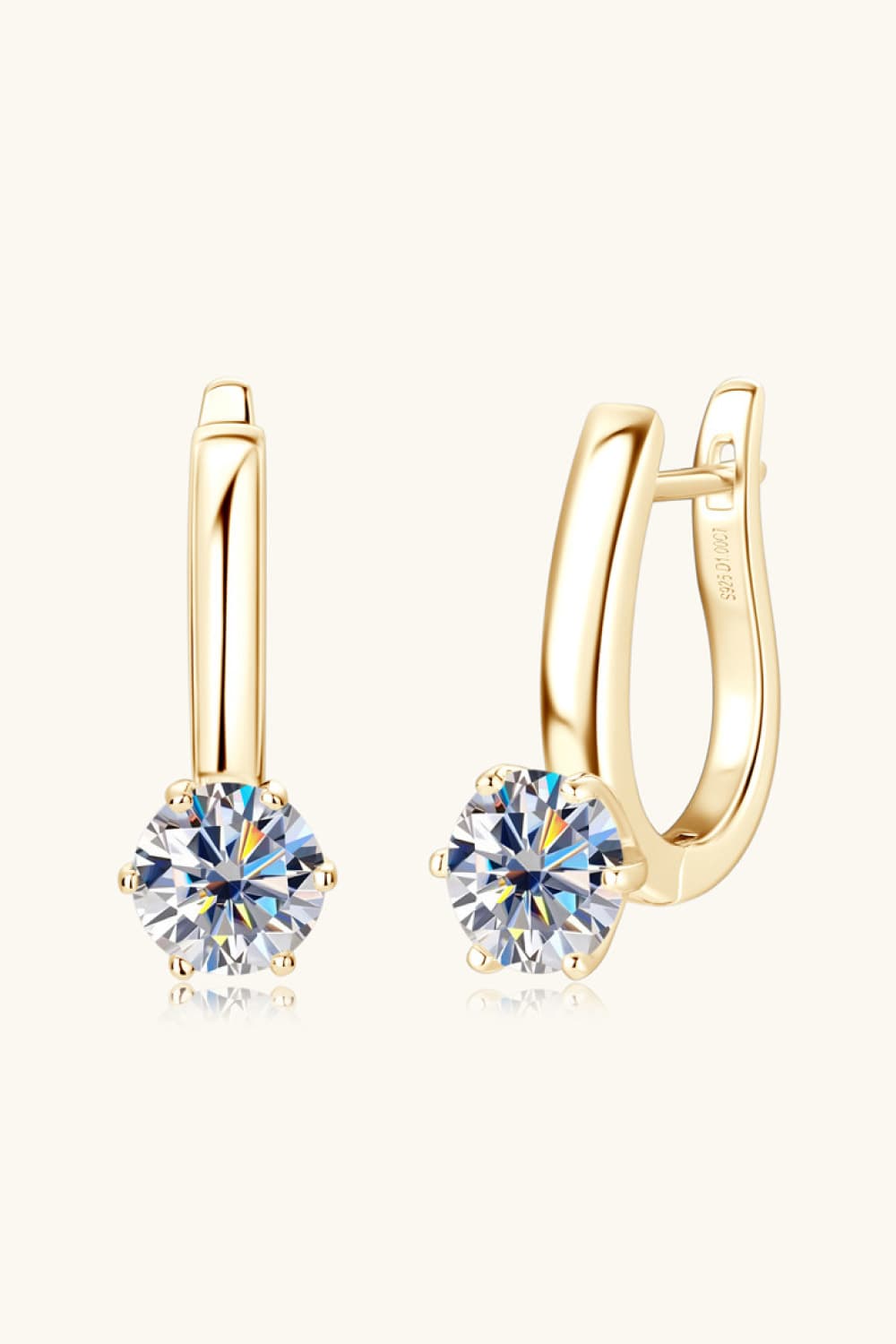 Gold solitaire huggie hoop earrings with clear cubic zirconia stones.
