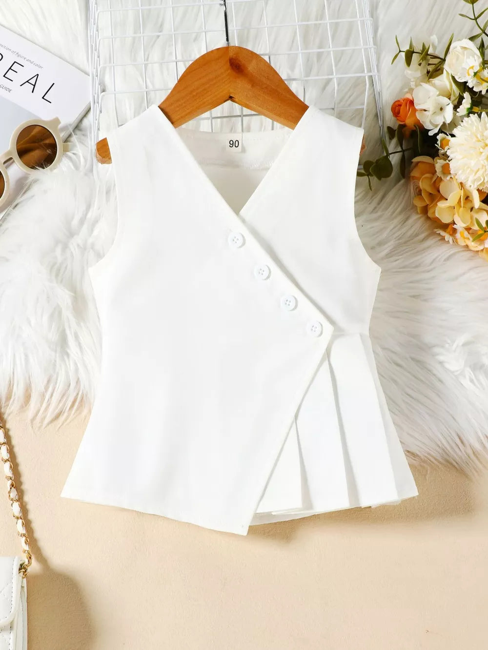 White baby sleeveless top with V-neck, button detail, and pleated hem