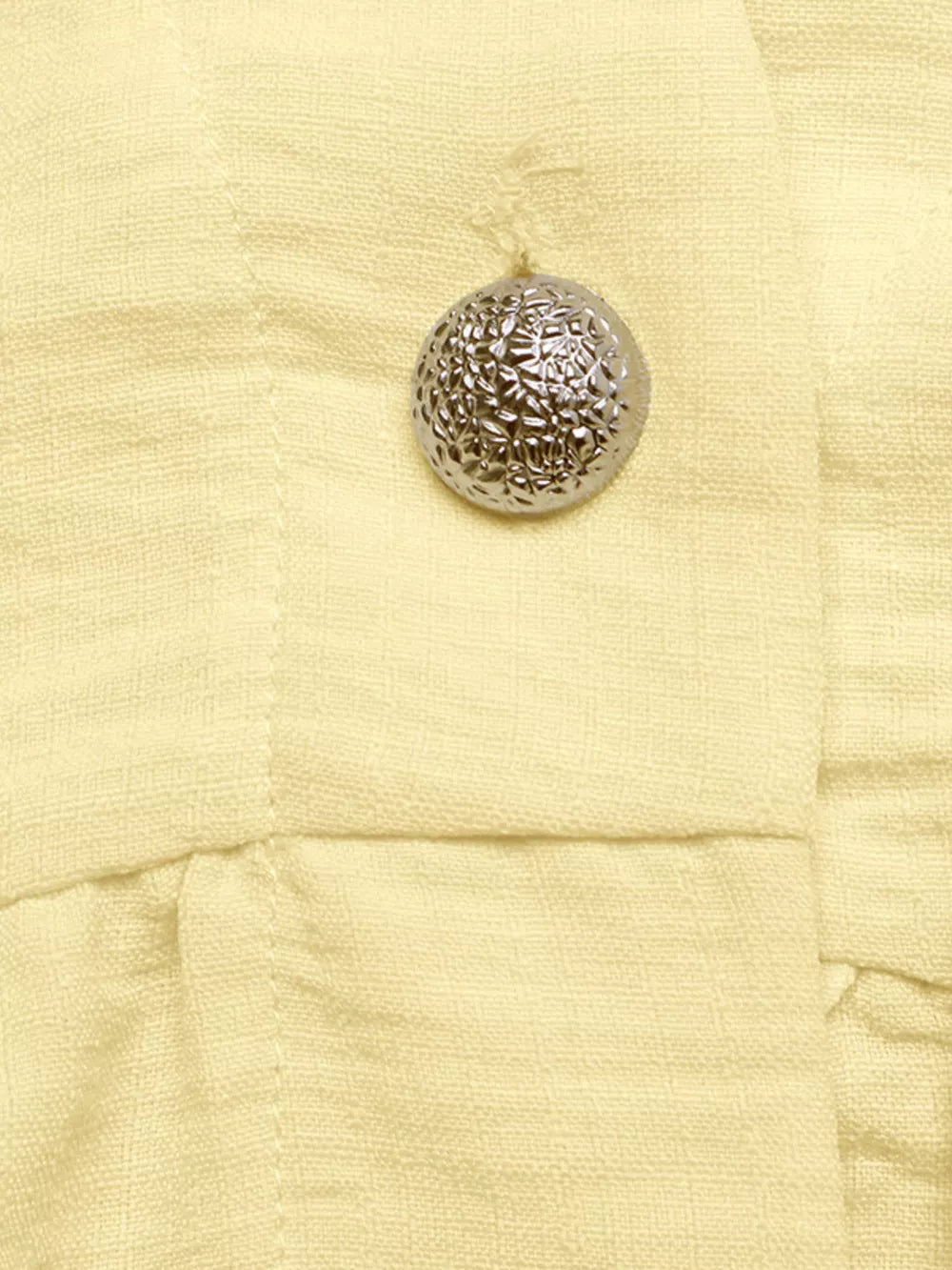 Yellow peplum hem two-piece set detail with textured silver button.