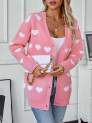 Blush pink acrylic knit cardigan with white heart pattern and button front.
