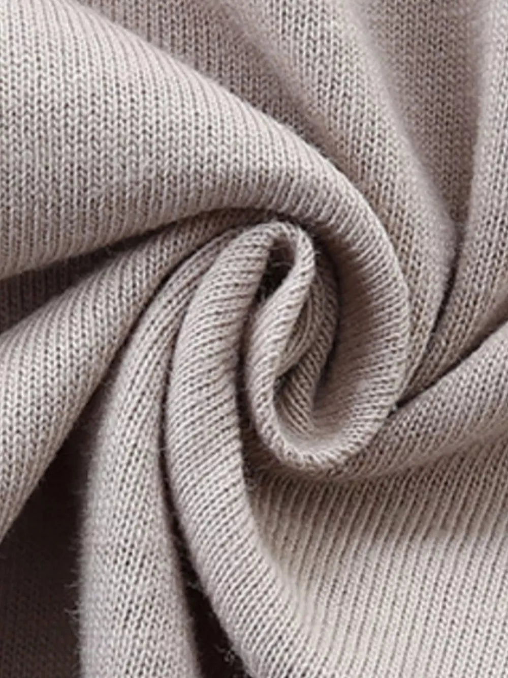 Close up of beige cotton knit fabric detail on a baby t-shirt.