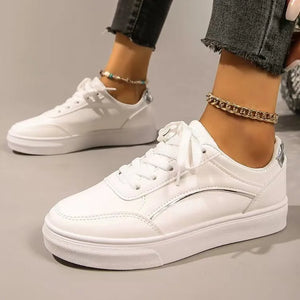 White sneakers with metallic trim and lace-up closure.