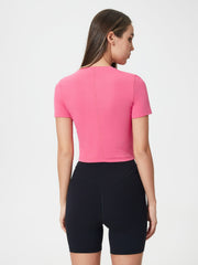 Fuchsia pink cropped performance crew neck top with short sleeves.