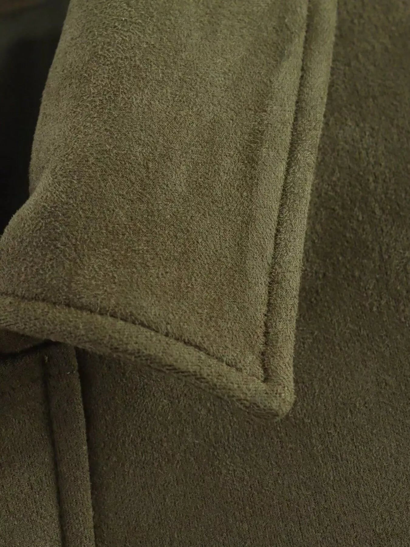 Oversized zip-up jacket in military green suede with visible stitching detail.