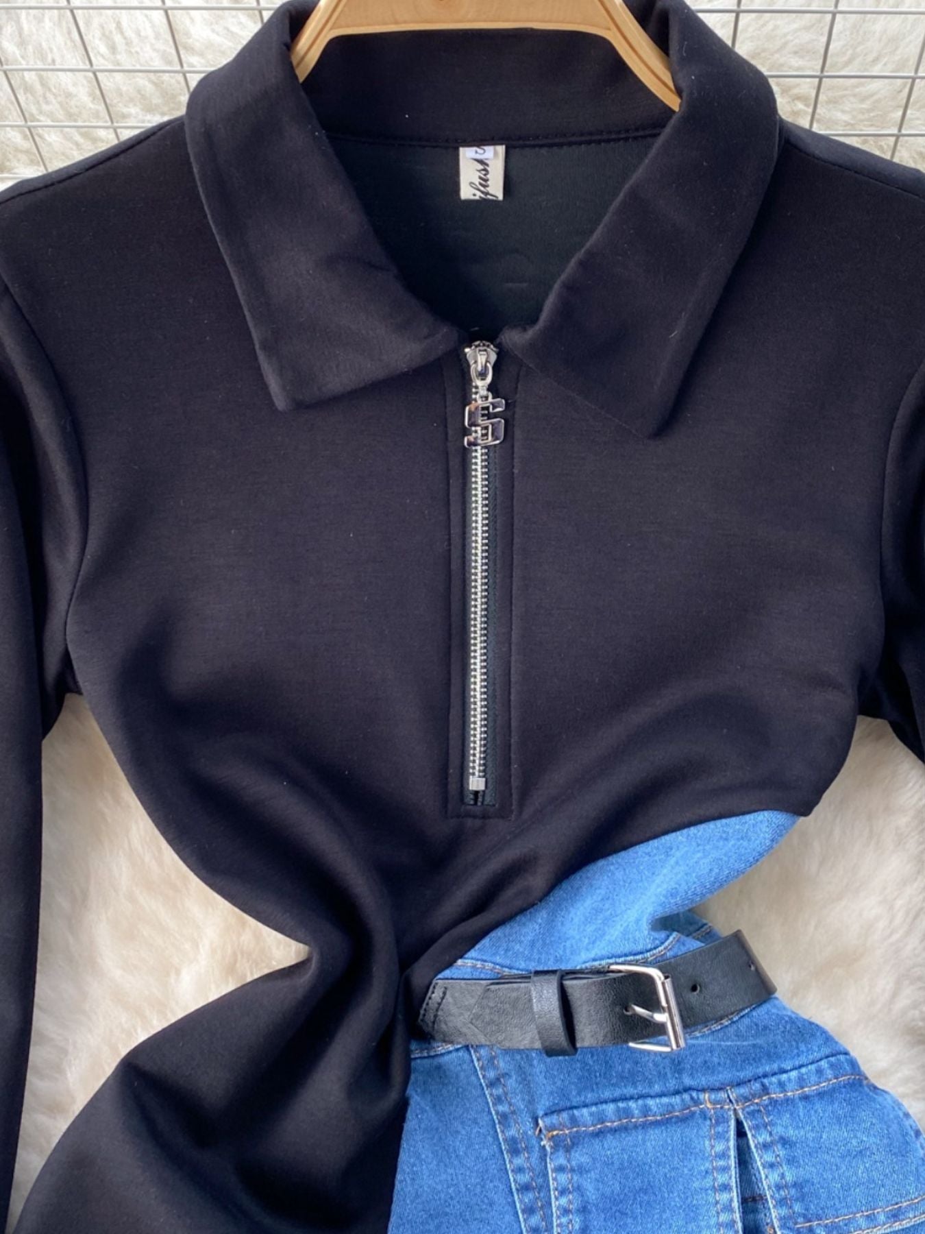 Black denim patchwork mini dress with a belted waist and quarter zip collar.