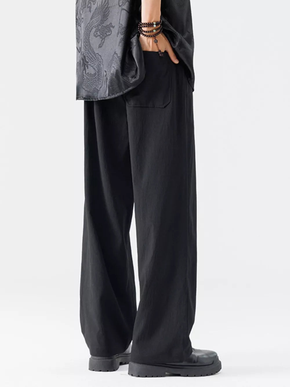Black wide-leg men's sweatpants with embroidered detail on shirt