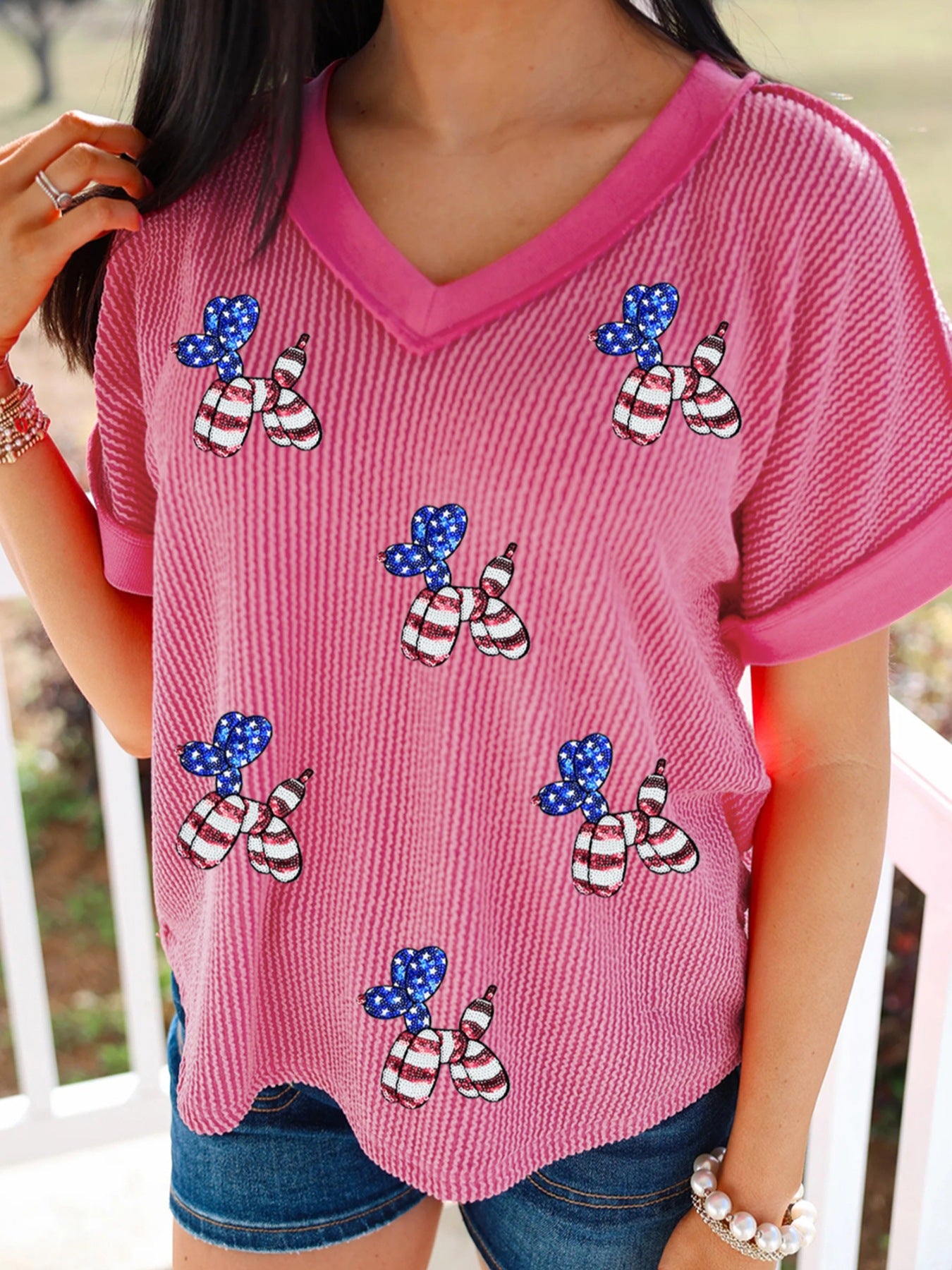 Pink striped V-neck tee with patriotic sequin balloon dog graphic.