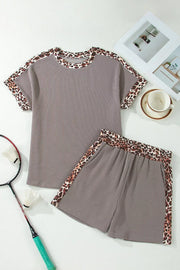 Brown ribbed knit two-piece set with leopard trim on neckline, sleeves, and shorts.