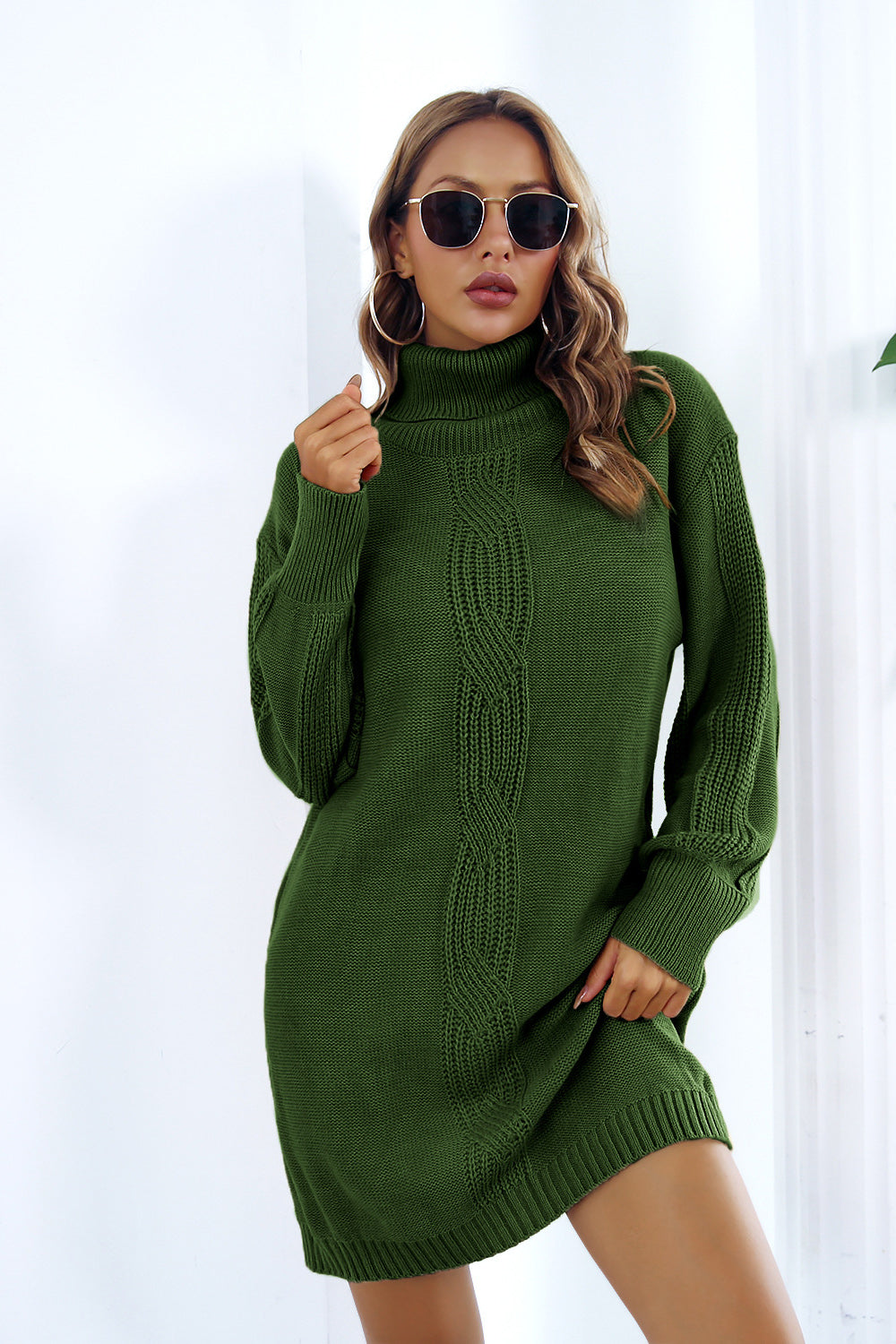 Green cable knit turtleneck sweater dress with blouson sleeves and a relaxed fit.