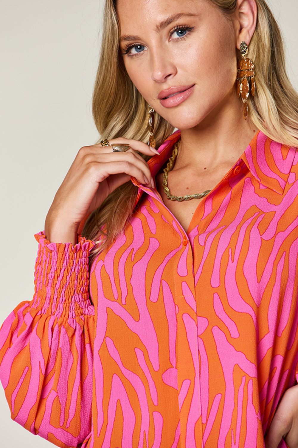 Orange and pink zebra print blouse with shirred cuffs and collared neckline.
