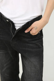 Dark wash denim trousers with exaggerated flare, shown with a hand in pocket.