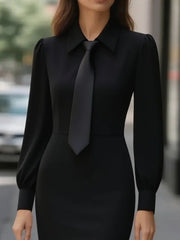 Black tie-neck long sleeve dress with buttoned collar and puff sleeves.