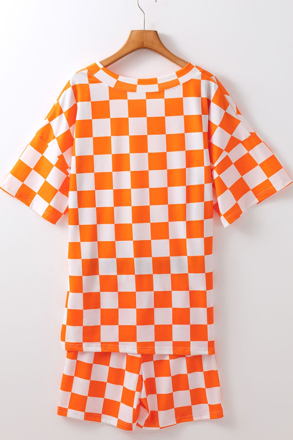 Checkered orange and white t-shirt and shorts set with crew neck and short sleeves.