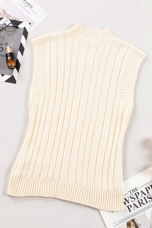 Ivory cable knit mock neck vest with ribbed texture and sleeveless design.