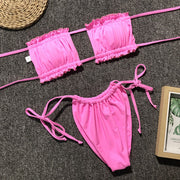 Pink ruffle bandeau bikini set with tie sides and ruched detail.