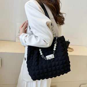 Black textured grid shopper bag with pearl and chain detail.