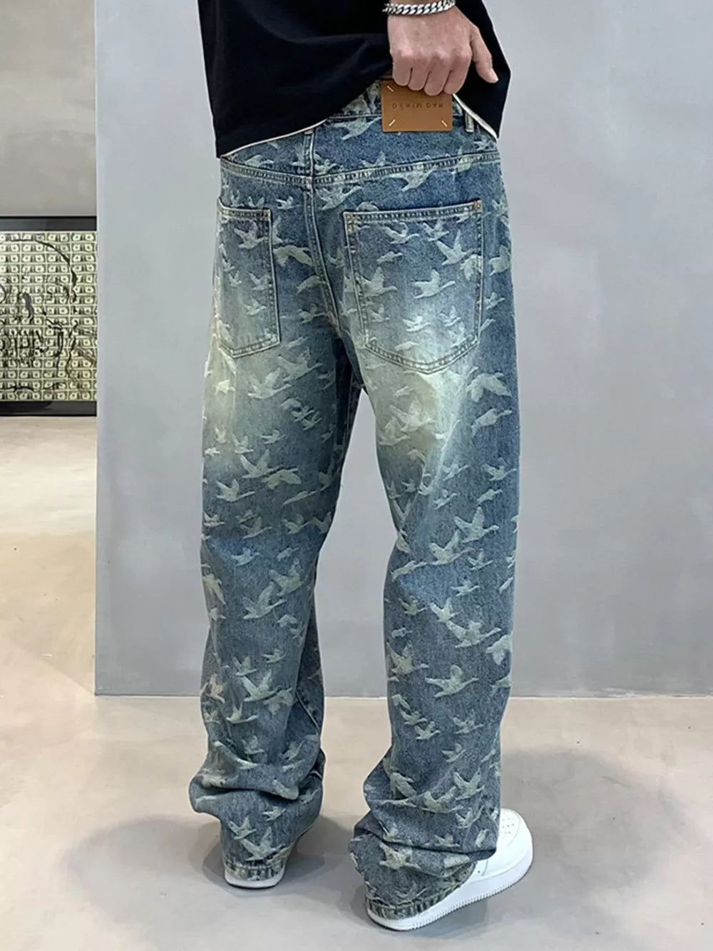 Loose-fit denim jeans with all-over bird print and distressed wash.