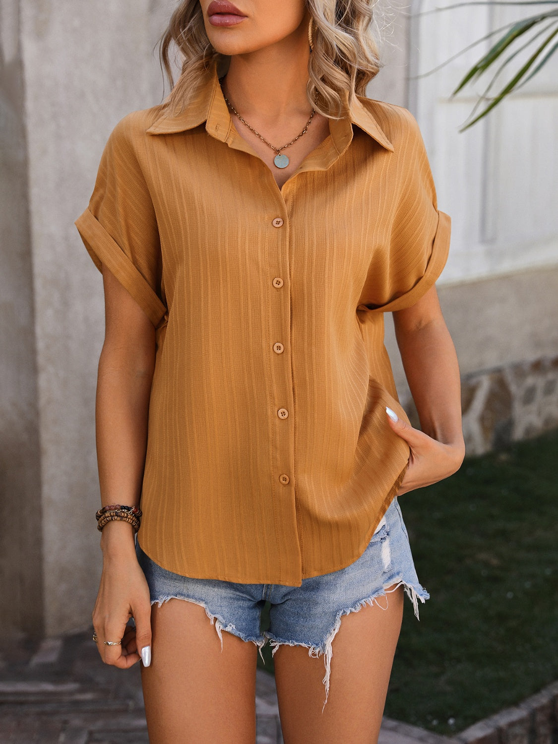 Mustard textured button-down shirt with cuffed short sleeves and a collared neckline.