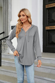 Light gray hooded henley top with button placket and drawstring, long sleeves, and pleated front.