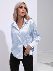 Light blue satin leopard print button-down shirt with a collared neckline and long sleeves.