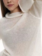 Sheer mock neck knit top in white with a draped neckline and fine knit texture.